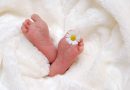Stopy niemowlęcia z kwiatkiem rumianku